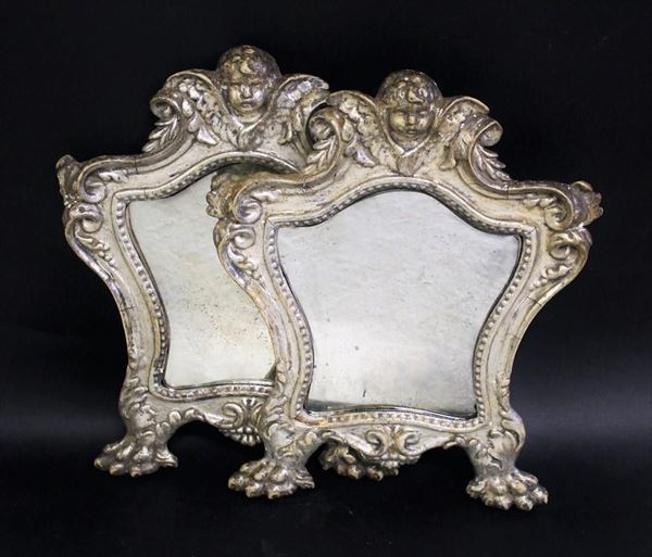 Coppia di Cartagloria, sec. XVII, in legno intaglaito e argentato a mecca, luce sagomata percorso da motivo perlinato, cimasa centrata da cherubino tra volute ingentilite da motivi fitoformi, piedi ferini, cm 36,5x29