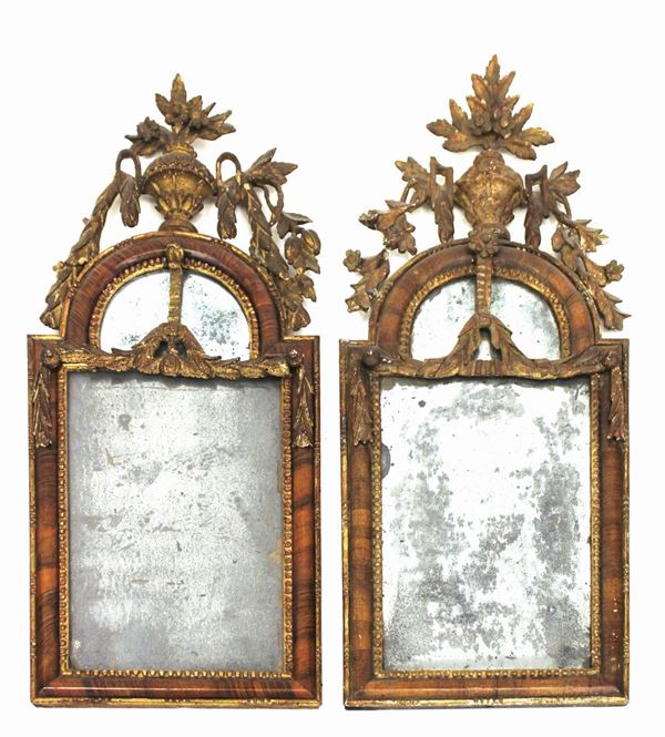 Coppia di specchiere, sec. XVIII, in legno lastronato e dorato, luce rettangolare a cimasa ad arco a tutto sesto, percorsa da motivo a perline, cimasa decorta a festoni, sormontata da motivo vasiforme intagliato a motivi fitoformi, cm 37x90, difetti e restauri