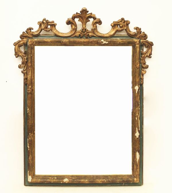 Specchiera, sec. XVIII, in legno intagliato, laccato e dorato, luce rettangolare, cimasa scolpita a volute contrapposte, cm 86x112