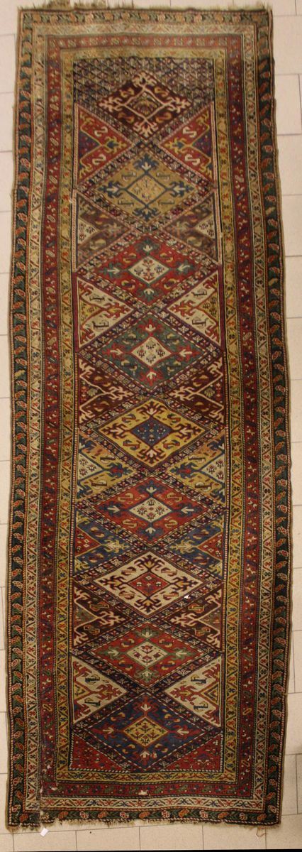 Tappeto passatoia, Caucaso, vecchia manfattura, impianto geometrico a losanghe multicolori, cm 400x127, numerosi difetti e rotture,&nbsp;