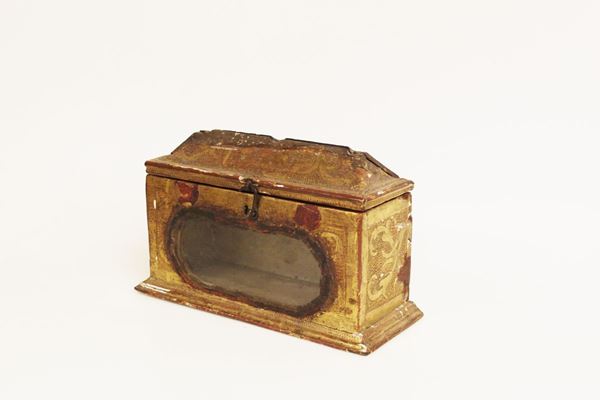 Lipsanoteca, sec. XVI, in legno dorato e bulinato, coperchio spiovente incernierato, fronte centrato da vetro ovale, cm 25x10x15