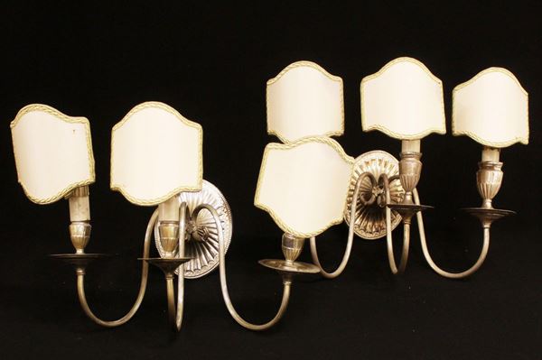Coppia di appliques, sec. XX, in metallo argentato, tre bracci a voluta   
