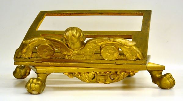 Leggio da tavolo, sec. XIX, in legno dorato e intagliato con volto di     