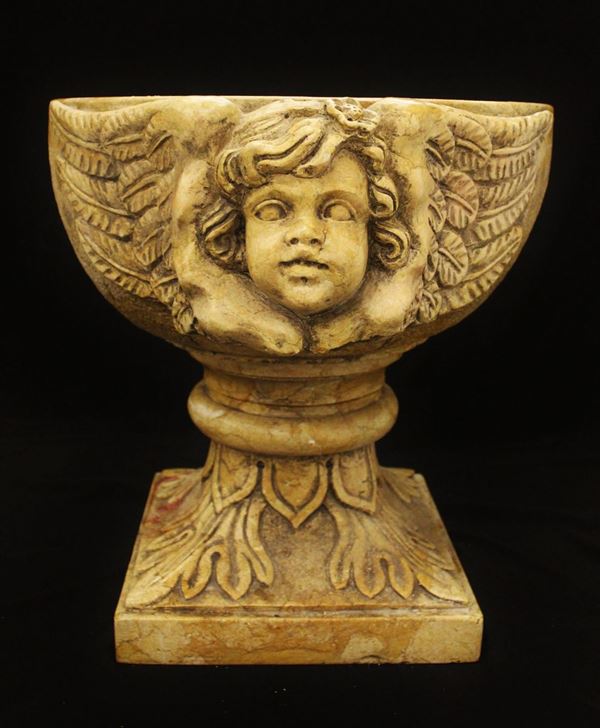 Acquasantiera, sec. XX, in marmo giallo di Verona, vasca decorata a coppia di cherubini su base quadrata scolpita a motivi fogliati, cm 70x50x53  - Asta ANTIQUARIATO, COLLEZIONISMO E GIOIELLI - Poggio Bracciolini Casa d'Aste