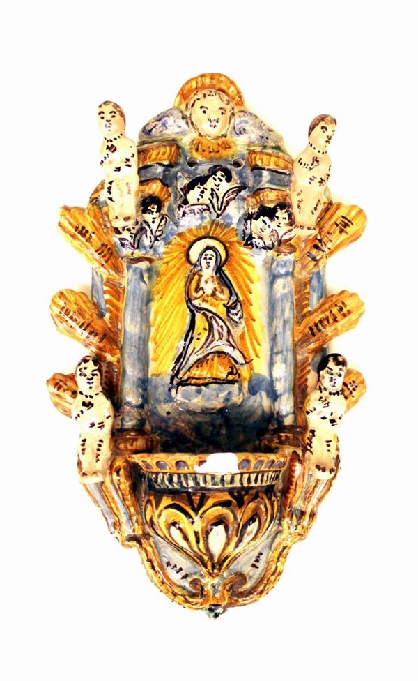 Acquasantiera, secolo XVII, in maiolica dipinta in policromia e modellata ad altorilievo con tempietto centrato da figura della Vergine con angeli e cherubini, probabilmente Italia meridionale, alt. cm. 32, una grossa sbeccatura frontale