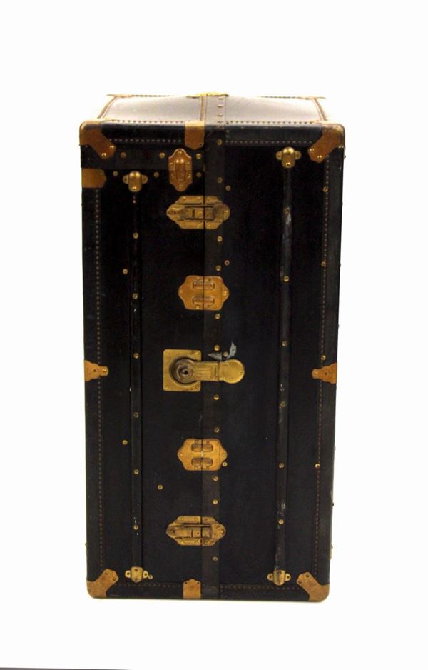 Baule armadio da viaggio, sec. XX, in legno laccato nero e rapporti metallici e borchiature bronzate, interno a cassetti e bastone appendiabiti, cm 60x60x115