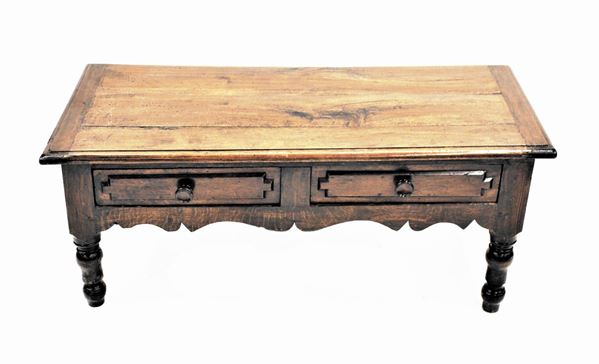 Tavolo basso, sec. XX, in rovere, piano rettangolare a becco di civetta sotteso da coppia di cassetti allineati dal fronte bugnato, fascia centinata, gambe tornite, cm 132x60x55