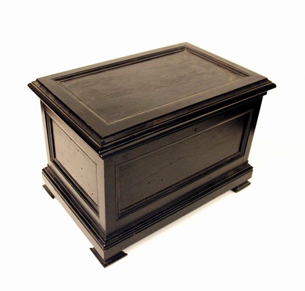 Cassina, sec. XIX, in legno ebanizzato piano rettangolare incernierato, interno rivestito in stoffa, base modanata, cm 41x27,5x28,5