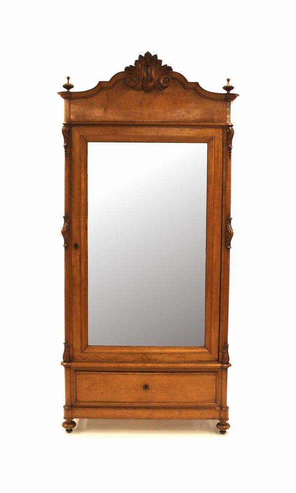 Armadio, Luigi Filippo, in ciliegio, cimasa a volute contrapposte centrate da motivo a scudetto araldico, fronte ad uno sportello con specchio, sotteso da cassetto a tutta lunghezza, piedi a trottola, cm 105x46x240, difetti