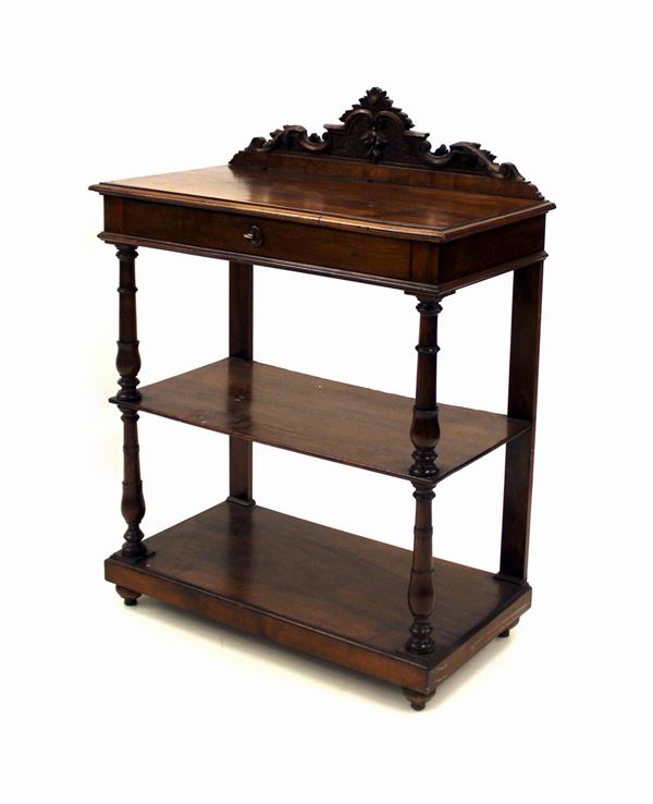Etagere, sec. XIX, in noce, piano rettangolare sormontato da cimasa a intagliata a volute centrata da motivo a pendoni fruttati, cassetto nella fascia, due scaffali tra elementi torniti, piedi a trottola, cm 89x47x119