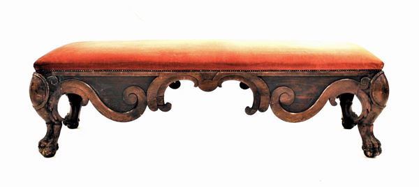 Panca, in stile 700, seduta rettangolare rivestita nei toni del rosso, fascia modanata ad ampie volute contrapposte, gambe mosse desinenti in piede ferino su sfera, cm 184x64x55, difetti
