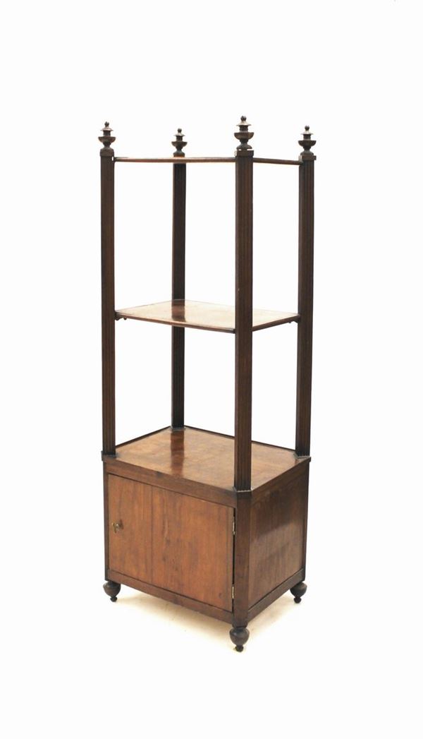 Etagere, sec. XIX, in mogano, profilo ad angoli scantonati tre ripiani tra montanti a plinto scannellato&nbsp; desinenti in finali a pinnacolo, uno sportello sul fronte, piedi torniti, cm 61x46x176, difetti