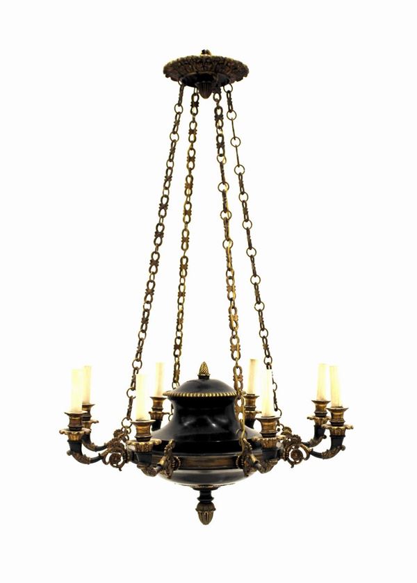 Lampadario, in stile Impero, in bronzo brunito e dorato, a otto bracci ricurvi decorati a rosette con attacco fogliato, bobeches dorate intagliate a motivi vegetali stilizzati, parte inferiore centrata da rosone dorato cesellato a elementi fogliacei lanceolati desinenti in motivo pigna, alt. cm 95, diam. cm 60