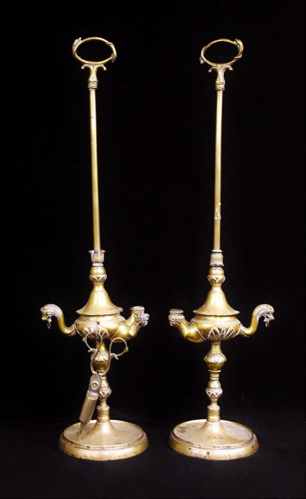 Coppia di lucerne in ottone, metà sec. XIX, a due fuochi e presa modellata a motivi zoomorfi piede circolare, alt. cm 63 (2)                                                                