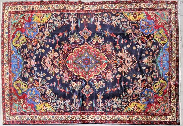 Tappeto persiano, sec. XX, impianto Kirman, medaglione centrale e cantonali multicolre su campo blu, cm 218x310