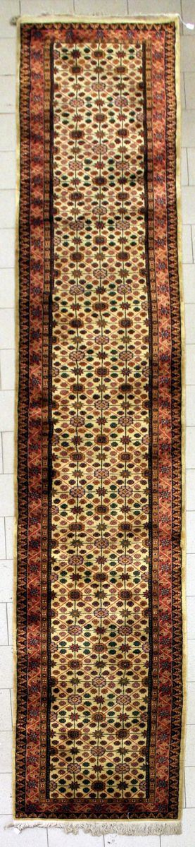 Tappeto passatoia, sec.XX, impianto geometrico, campo nei toni del beige, fasci a di bordura nei toni del rosso, cm 590x90