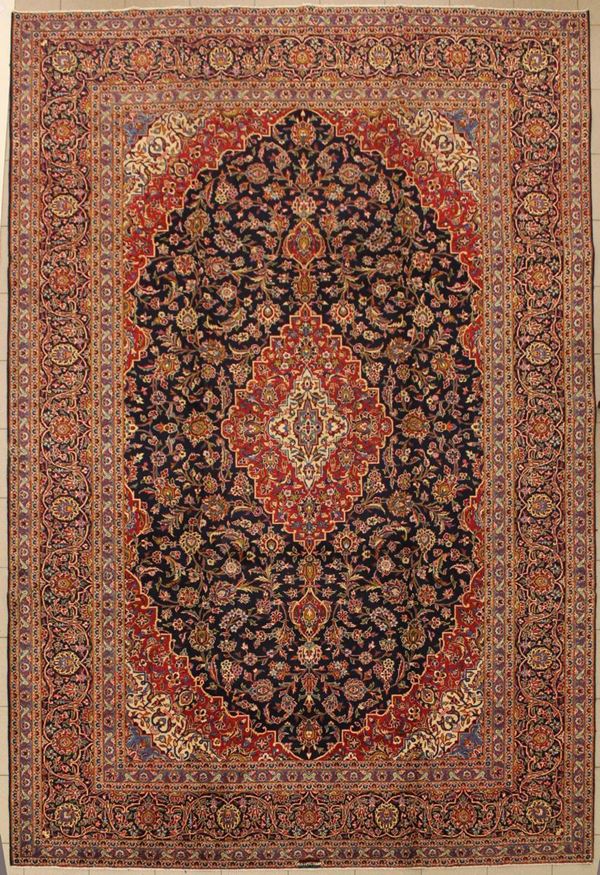 Tappeto persiano, Keishan, di vecchia manifattura, firmato, campo a motivi floreali nei toni del blu del beige e del rosso, cm 385x270