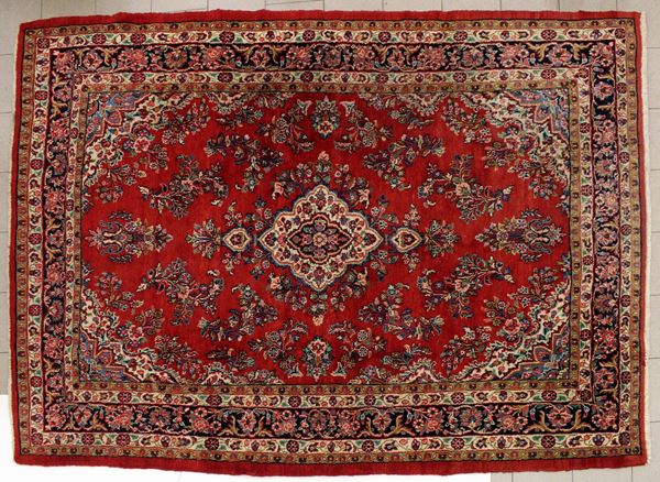 Tappeto persiano Saruk, met&agrave; sec. XX, fondo rosso a motivi floreali, cm 325x225