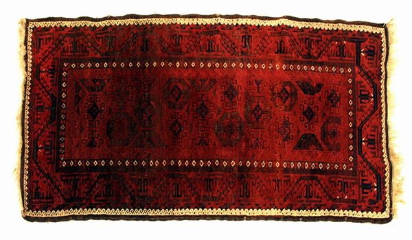 Tappeto Turcomanno, sec. XX, impianto geometrico nei toni del rosso, cm 187x95