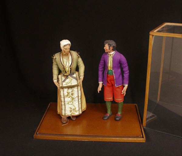 Coppia di pastori, Napoli, sec. XX, in terracotta dipinta, abbigliati in vesti policrome, entro teca in vetro, cm teca, cm 41x26x39