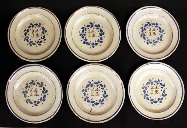 Sei piatti, sec. XIX, in maiolica dipinta, motivo anulare nei toni del blu a delimitare la tesa, cavetto centrato da monogramma entro ghirlanda fogliata, diam. cm, 24,5 (6)