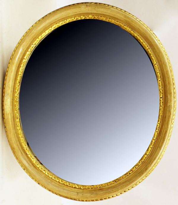 Specchiera, inizio sec. XIX, in legno laccato e dorato, luce ovale percorsa da motivo a foglioline, cm 110x126