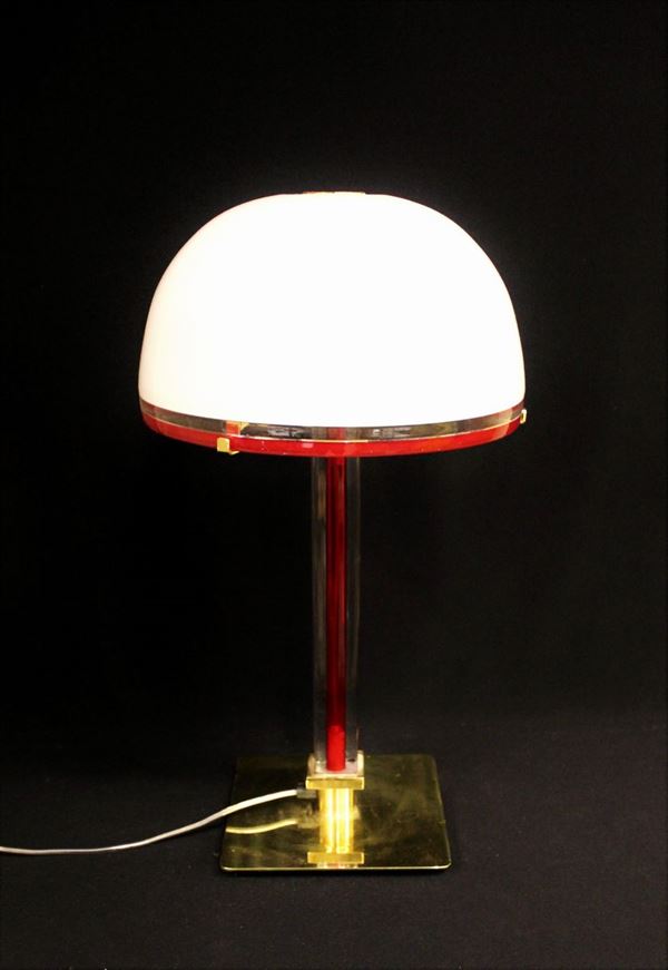 Lampada da tavolo, Murano, sec. XX, manifattura Venini, modello Tolboi, in vetro incolore, lattimo e rosso, finiture in metallo dorato, alt. cm 54