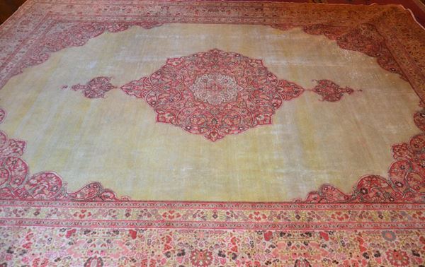 Tappeto periano, inizi sec. XX, fondo avana, borchia centrale nei toni del rosso; cm 430x340