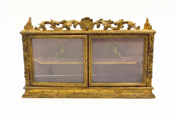 Vetrina pensile, sec. XVIII, in legno dorato e intagliato, cimasa a foglie  - Asta GIOIELLI, ARGENTI, E OPERE DI ARTE ANTICA E CONTEMPORANEA - Poggio Bracciolini Casa d'Aste