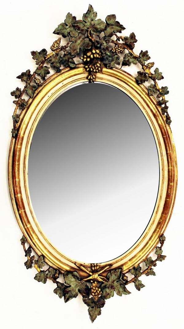 Specchiera, sec. XIX, in legno e stucco laccato e dorato, luce ovale,&nbsp;&nbsp;&nbsp;&nbsp;&nbsp;