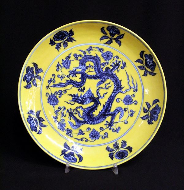 Piatto, Cina, sec. XX, in porcellana a campo giallo, scesa decorata a&nbsp;&nbsp;&nbsp;&nbsp;&nbsp;
