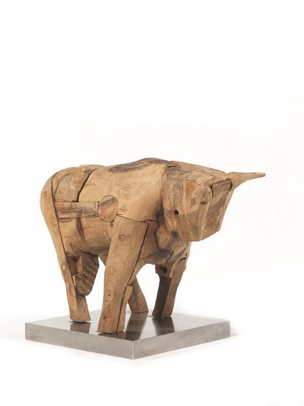Scultura, sec. XX, in legno di olivo raffigurante toro, su base in metallo,