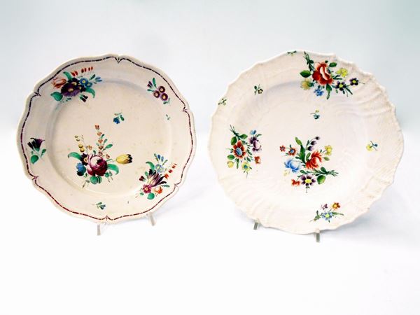 Due piatti, sec. XIX, in maiolica con decori a fiori, diam. cm 25 e cm 24,