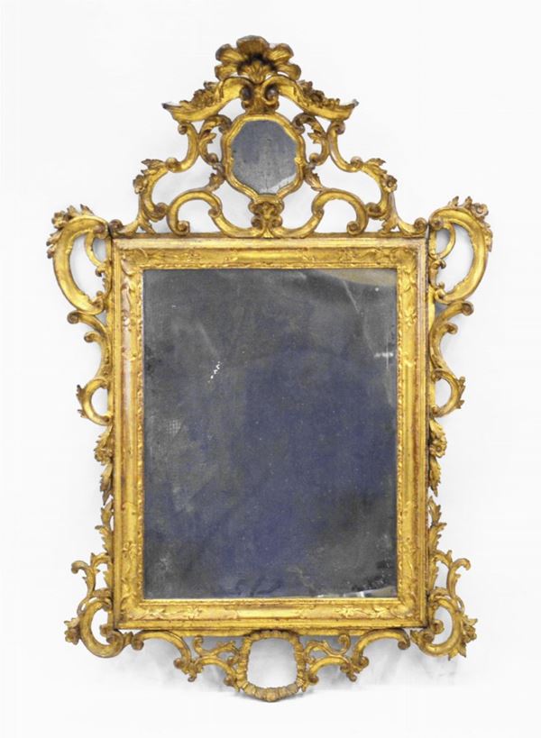 Specchiera, in stile Luigi XV, entro cornice in legno dorato e intagliato a