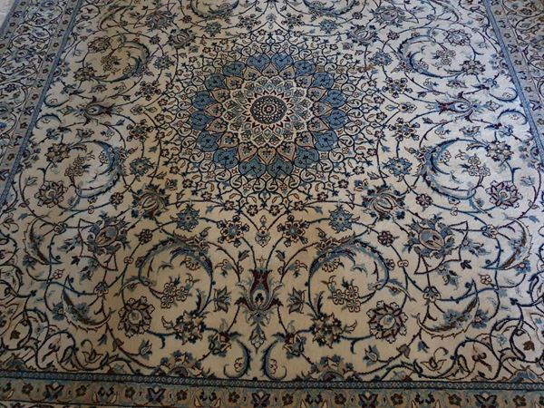 Tappeto persiano Nain, sec. XX, fondo avana e azzurro a motivi floreali, cm