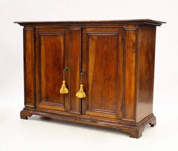 Credenza, sec. XVIII, in noce, due sportelli sformellati,&nbsp;&nbsp;&nbsp;&nbsp;&nbsp;&nbsp;&nbsp;&nbsp;&nbsp;&nbsp;&nbsp;&nbsp;&nbsp;&nbsp;&nbsp;&nbsp;&nbsp;