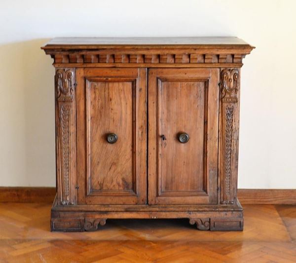 Credenzino, sec. XVII, in noce, piano rettangolare sotteso da moivo a     