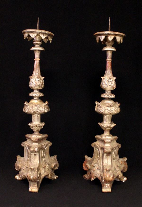Coppia di candelieri, sec. XVIII, in legno intagliato e argentato, fusto ad