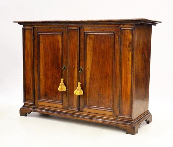 Credenza, sec. XVIII, in noce, due sportelli sformellati,&nbsp;&nbsp;&nbsp;&nbsp;&nbsp;&nbsp;&nbsp;&nbsp;&nbsp;&nbsp;&nbsp;&nbsp;&nbsp;&nbsp;&nbsp;&nbsp;&nbsp;