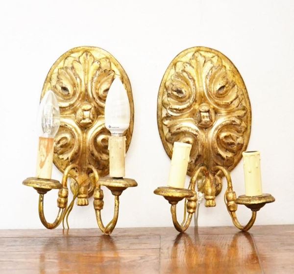 Coppia di applique, in stile 700, in legno intagliato e dorato due luci, cm