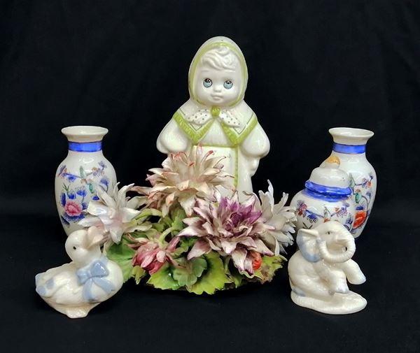 



Lotto composto da tre vasetti, due soprammobili, una bambolina e un centrotavola raffigurante composizione di fiori, sec. XX, in maiolica, alt. da cm 8 a cm 22 