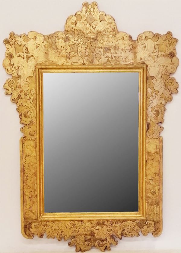 



Specchiera, sec. XIX, entro cornice in legno dorato, intagliato e inciso a motivi floreali,