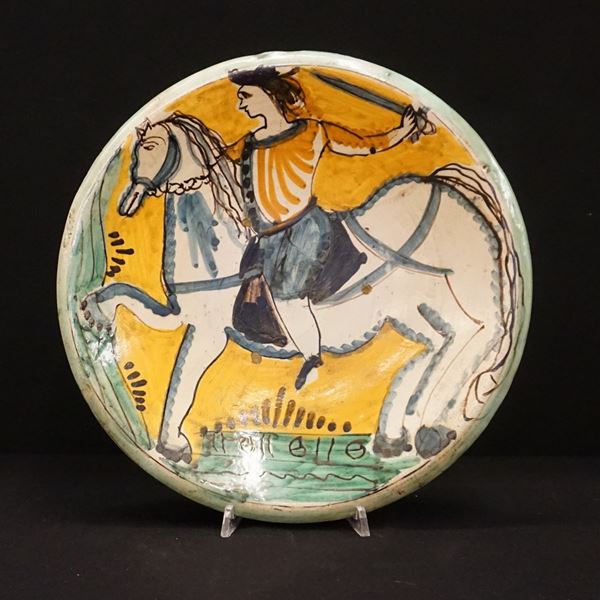 



Piatto da parete, Montelupo, sec. XIX, in maiolica dipinta in policromia raffigurante cavaliere con spada, diam. cm 30,5