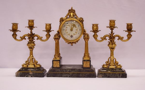 



Orologio e coppia di candelieri, in stile Impero