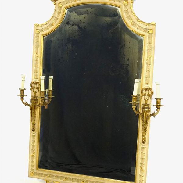 



Specchiera, sec. XX, in legno laccato e intagliato, ai lati due applique a due luci in metallo dorato, 100x145