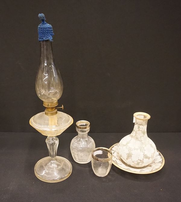 



Lampada a petrolio, un vaso con vassoio, un bicchiere ed un vasetto