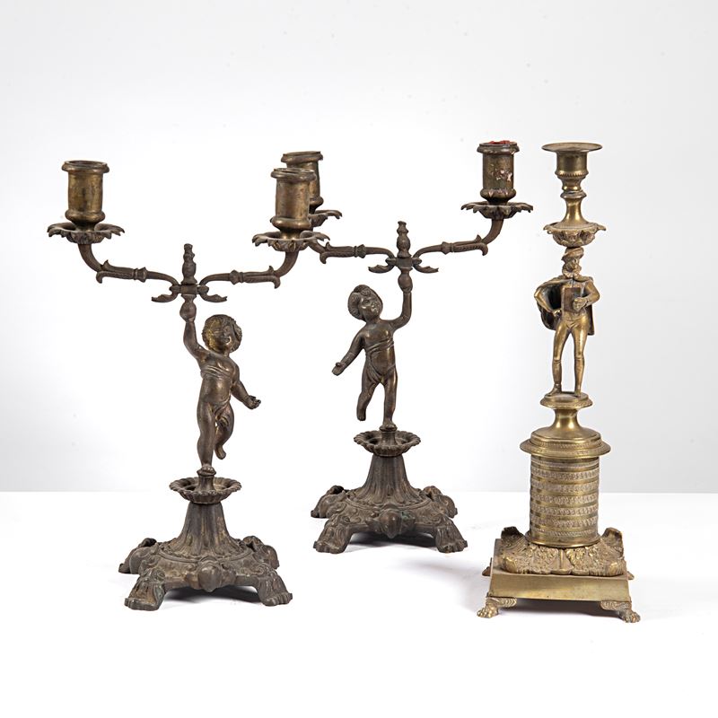 Coppia di candelieri, sec. XX, in metallo e bronzo con figure decorative